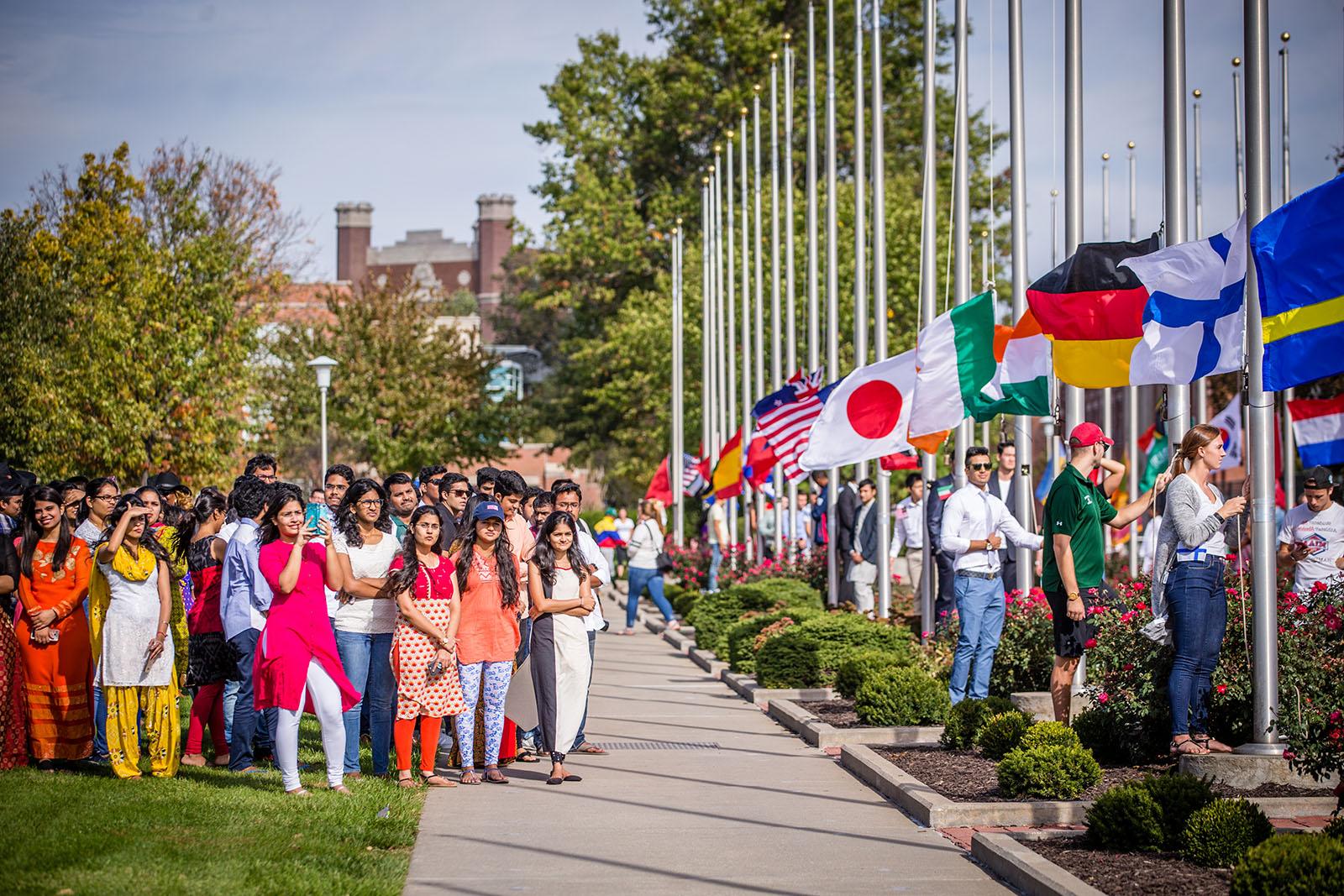 在和记棋牌娱乐每年秋天的升旗仪式上, 大学的国际社团聚集在一起，学生们按照联合国的规定升起自己国家的国旗.